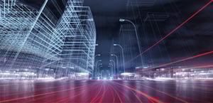 Futuristische Stadt bei Nacht mit Lichtspuren von Fahrzeugen und digitalen Drahtgitterstrukturen von Gebäuden.